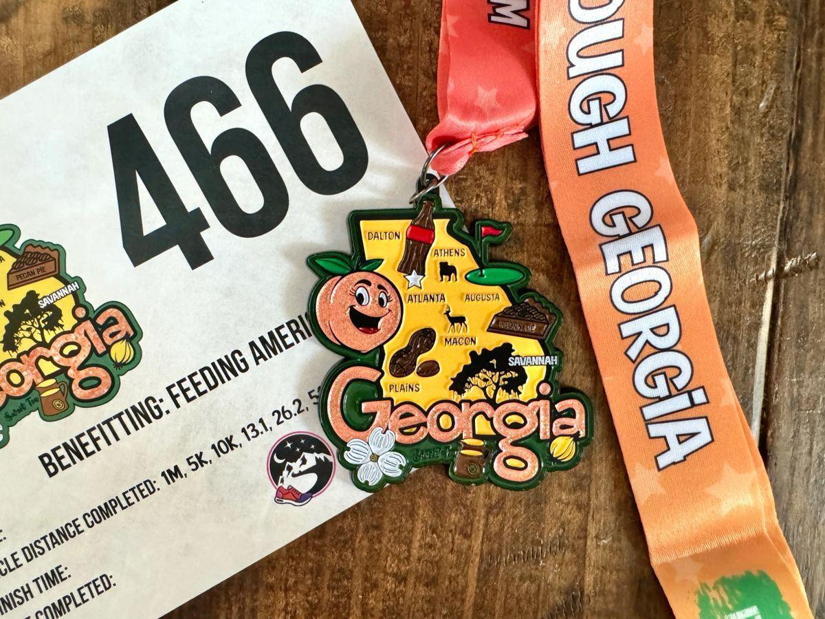 All 50 race medals and bibs from the Race Through America Series by virtualrunevent displayed together.