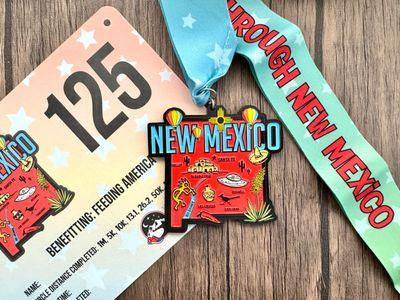 Virtualrunevent Race Through America 50 State Challenge medals and bibs displayed on a white background.
