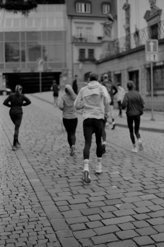 a group of people running down a brick road