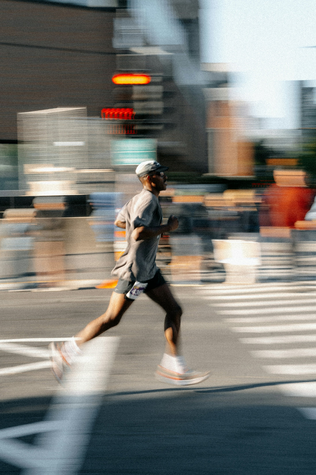Man running across a blurred city street