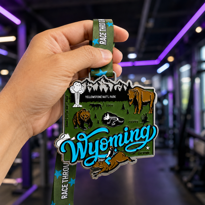 Hand holding a medal for the Race Through Wyoming virtual race, featuring a Wyoming-themed design for 5K, 10K, half marathon, and marathon.
