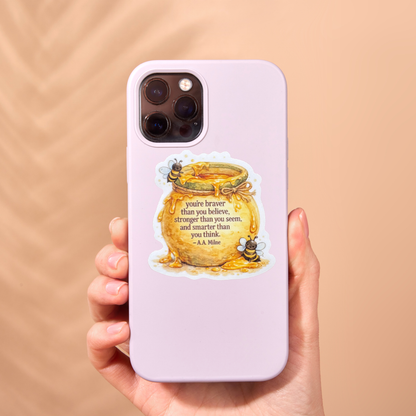 Medal with "Braver Than You Believe" inscription, virtualrunevent sticker featuring a motivational design on a shiny metal surface.