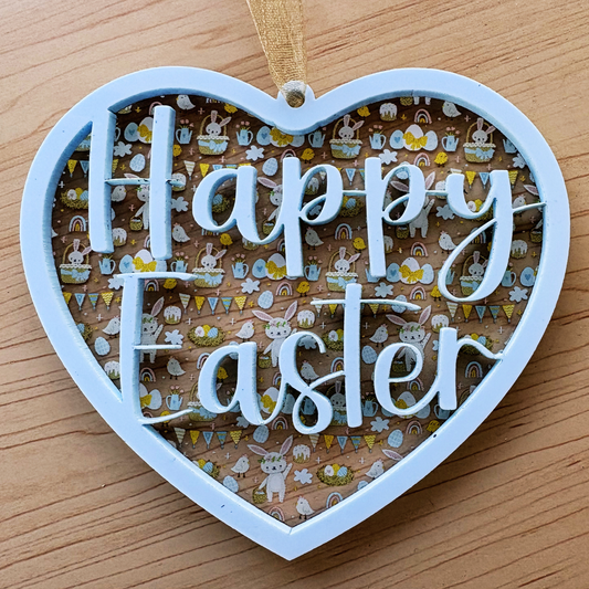 Decorative acrylic Easter ornament in heart shape, layered design with printed spring and garden motifs, 3.75 inches tall.
