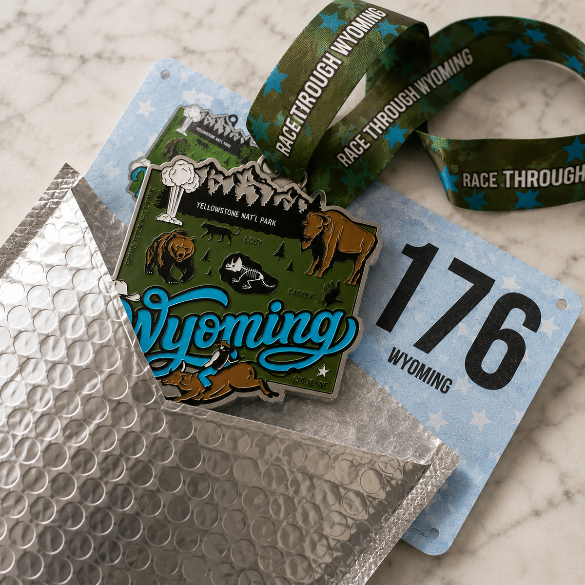 Virtualrunevent Race Through Wyoming medal featuring Wyoming landscape and race details, displayed outside a padded envelope.